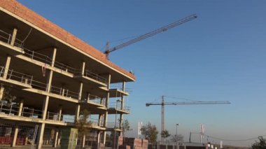 Seville, İspanya-03 Ocak 2019: 4k, tuğla ustası inşaat alanında inşaat duvarları oluşturmak için beton harç kullanarak kırmızı kil tuğlaları döşedi. Güneşli bir günde inşaat halinde olan bir ev.