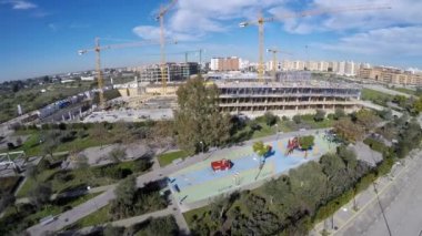 4K, hava aracı güneşli bir günde inşaat halindeki yeni bir binayı vurdu. Güzel panoramik manzaralı bir inşaat vinci şehirde çalışıyor. Yukarıdaki Dan 'den arkaplan