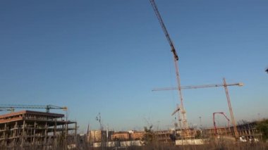 Seville, İspanya-03 Ocak, 2019: 4K, Endüstriyel kule vinçleriyle inşaat halindeki ev. İnşaat vinci şehirde bir evde çalışıyor. Güneşli bir günde inşaat halindeki yeni bina - Dan