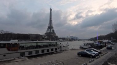 Paris, Fransa-13 Ocak 2018: 4K, Eyfel Kulesi ve Fransa 'da kış günü tekneli Seine nehri. Avrupa 'nın ünlü turistik yerlerinde bulutlu bir gökyüzü. Eiffel 'in arka planında yağmurlu bir gün
