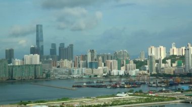 Hong Kong Şehri şehir manzarası bulutları, Kowloon Körfezi 'nin yakınındaki ufuk çizgisi liman önünde gemileri ve arabaları ile birlikte.