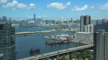 Hong Kong Şehri şehir manzarası bulutları, Kowloon Körfezi 'nin yakınındaki ufuk çizgisi liman önünde gemileri ve arabaları ile birlikte.