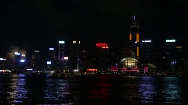 Geceleri gökdelenleri olan Hong Kong Adası gökdelen manzarası, Victoria Limanı 'ndaki Pearl nehri üzerinde gemileri ve tur tekneleri olan Kowloon şehri manzarası.