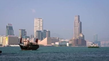 Victoria Limanı 'nda 4K Junk teknesi. Hong Kong yolcu gemisinin sembolü geleneksel Çin tarzında kırmızı yelkenli modern Hong Kong-Dan 'in yüksek binalarının arka planında