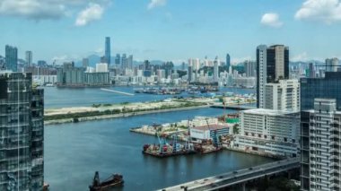 4k Timelapse Top View of Hong Kong Modern Gökdelenler günü Kowloon Körfezi 'nde tekne ve araçlarla limanın önünde