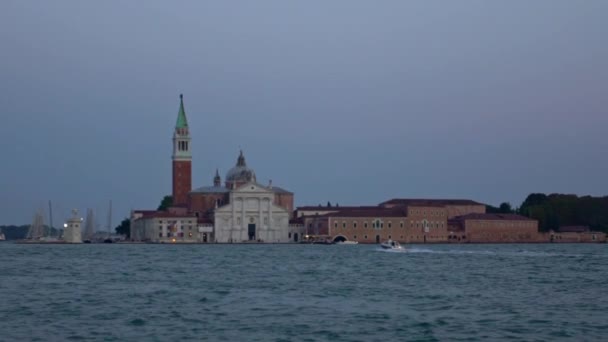 遅い背景に教会サン ジョルジョ マッジョーレ島と海の中でボート旅行で警察の動き 月と夜のヴェネツィアのパノラマ イタリア — ストック動画