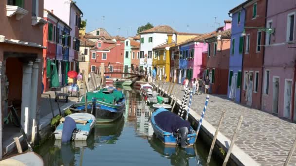ヴェネツィア イタリア 2018 4K島ブラーノ島のカラフルなヴェネツィアの家のファサードと通りの運河の橋に渡す人々 彩色アパートを訪れる観光客 — ストック動画