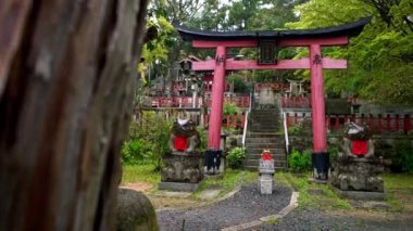 4K, Suehiro ogami tapınağı. Yağmur gününde Fushimi Inari Taisha baş mabedinin çıkışında kırmızı önlüklü taş heykel ve kurbağa heykeli. Fuku Kaeru ya geri dön ya da Japonya 'ya dön demek.
