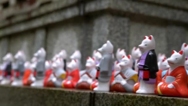 有名な神社で幸運キツネの数百人の小さな像 伏見稲荷大社の小さな寺院で美しい日本のお守り 日本の聖域における狐の信仰 Dan — ストック動画