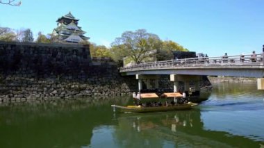 4K, Osaka Kalesi hendeği boyunca turistli tekneler. Japonya 'nın Kansai bölgesinde Japon sembolü. Turist için ünlü bir yer. Eski miras binasının güzel manzaraları. -Dan.