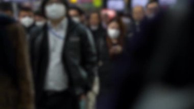 Yavaş çekim bulanık görüşlü Japon iş adamları ve kadınlar yüz maskesi takıyor. Koronavirüs sırasında Wuhan, Çin-Dan 'den tedbir olarak metro maskesi takan insanlar.