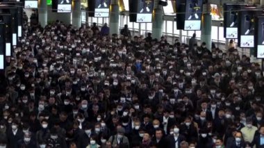 Tokyo, Japonya-04 Şubat 2020: Japon yolcuların yavaş çekim görüntüsü Coronavirus enfeksiyonunu önlemek için Shinagawa İstasyonu 'nda maske takıyor. Virüs acil duruma neden oldu.