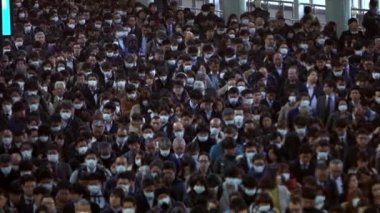 Tokyo, Japonya-04 Şubat 2020: yavaş çekim hava görüntüsü Japon iş adamları ve kadınlar yüz maskesi takıyor. Koronavirüs sırasında Wuhan, Çin-Dan 'den tedbir olarak metro maskesi takan insanlar.