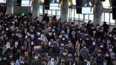 Tokyo, Japonya-04 Şubat 2020: Japon yolcuların yavaş çekim görüntüsü Coronavirus enfeksiyonunu önlemek için Shinagawa İstasyonu 'nda maske takıyor. Virüs acil duruma neden oldu.