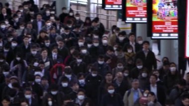 Tokyo, Japonya-04 Şubat 2020 Shinagawa İstasyonu 'ndaki iş adamlarının yavaş çekim görüntüsü. Metro, günlük kullanımıyla dünyanın en işlek ulaşım merkezi. Japon yolcular yürüdü - Dan