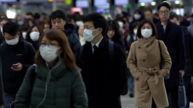 Tokyo, Japonya-04 Şubat 2020: Ağır çekimde Japonlar Coronavirus enfeksiyonunu önlemek için Shinagawa İstasyonu 'nda maske takıyorlar. Virüs acil duruma neden oldu.