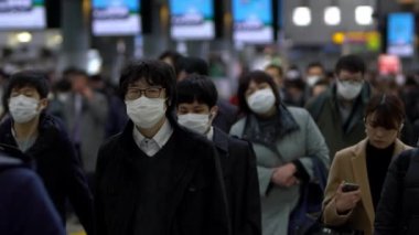 Tokyo, Japonya-04 Şubat 2020: Ağır çekimde Japonlar Coronavirus enfeksiyonunu önlemek için Shinagawa İstasyonu 'nda maske takıyorlar. Virüs acil duruma neden oldu.