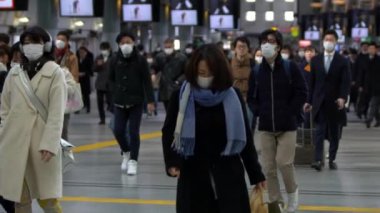 Tokyo, Japonya-04 Şubat 2020 metro çıkışında cerrahi maske takan kalabalık yavaş hareket ediyor. Coronavirus pnömonisi şehirlere yayılıyor. 2019-NCoV Çin-Dan salgını