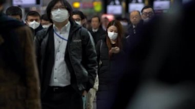 Tokyo, Japonya-04 Şubat 2020: Japon iş adamlarının yavaş çekimleri yüz maskesi takıyor. Koronavirüs sırasında Wuhan, Çin-Dan 'den tedbir olarak metro maskesi takan insanlar.