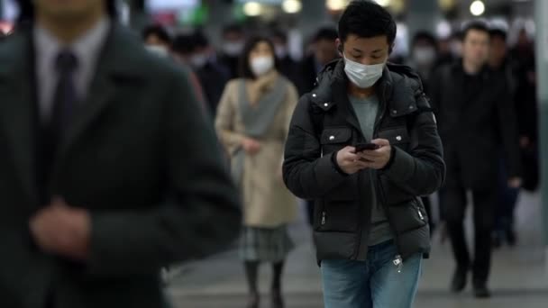 日本东京2月4日电 2020年2月4日 日本慢动作旅行者在新川车站使用手机时佩戴口罩 以防止感染头孢病毒 这种病毒造成了紧急情况 — 图库视频影像