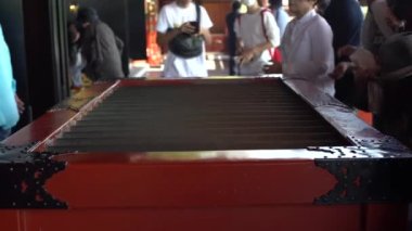Tokyo, Japonya-01 Ekim 2017: 4K Turistler ve dindar ziyaretçiler Tokyo 'daki Sensoji Asakusa tapınağında kutuya sikke atmak için dua ediyorlar. İnsanlar Kinryu-zan Japonya 'daki ünlü Japon tapınağını ziyaret ediyor.