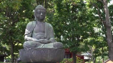 Yeşil çitleri ve ağaçları olan 4K Buddha heykeli. Asakusa 'daki ünlü Budist tapınağı Senso-ji' de huzurlu bir manzara. Japon tapınağı Sensoji Tokyo City, Japonya Kinryu-zan 'da. - Dan.