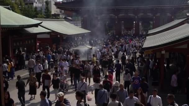 2017年10月1日 日本东京 4K人参观日本著名寺庙Sensoji Asakusa 向自己挥动来自骨灰盒的烟雾 改善健康 治愈疾病 日本神道金牛山丹神龛 — 图库视频影像