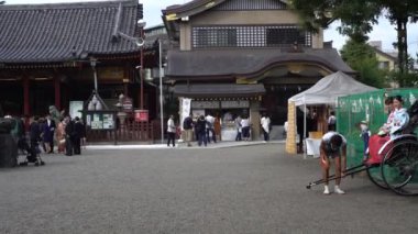 Tokyo, Japonya-01 Ekim 2017: 4K Japon geyşa kızları, fayton sürücüsü, Budist tapınağı Senso-ji Asakusa. Jinrikisha 'daki kadın yolcular, geleneksel Asya tekerlekli araba, Tokyo. Japonya-Dan