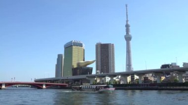 Nehir kenarındaki 4K Tokyo Skytree binasında turist gemisi gezisi var. Gökyüzü Ağacı, Sumida, Japonya 'da bulunan bir yayın ve gözlemdir. Dünyanın en yüksek yapı kulesinden biri.