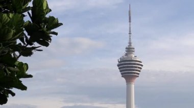 4K, Ünlü Kuala Lumpur iletişim kulesi Menara KL. Malezya 'da gökyüzü bulutlu televizyon anteni. Asya kentindeki finans bölgesi ve iş merkezlerinin havadan görüşü.