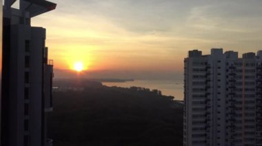 Singapur-Dan 'de günbatımı ve gökdelenleri olan doğu yakası parkının 4k hava manzarası