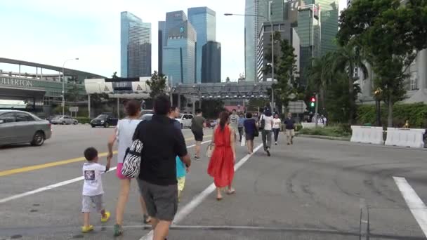 シンガポール2015年4月11日 ラッシュアワーの交通量と歩行者が市内中心部のシンガポールの交差点を歩く — ストック動画