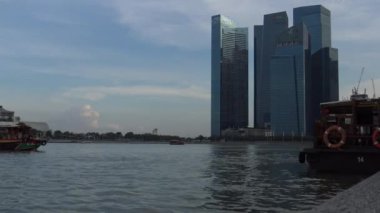 4k bir turist gemisi Singapur merkezinin arka planında şehir manzarası olan Marina Körfezi Kumları 'ndan geçiyor.