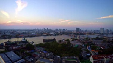 Traffic Cityscape Bangkok ile Harbor ve Street 'in 4K Timelapse Hava Görüntüsü. Günbatımının zamanlaması nehirde gemilerle ve gemiyle Tayland 'da gece gündüz köprüsüyle.