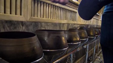 4K ziyaretçileri Wat Pho 'daki 108 bronz kaseye madeni para atıyorlar. Ayrıca Tayland-Tayland' ın Bangkok kentindeki Budist tapınağı olan Buda Tapınağı olarak da bilinir.
