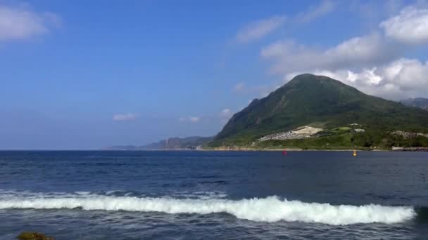 新北市の背景の基隆山と海の波のビーチビュー 山と青空と海岸線の風景 済山ダンの夏の美しい日の海岸 — ストック動画