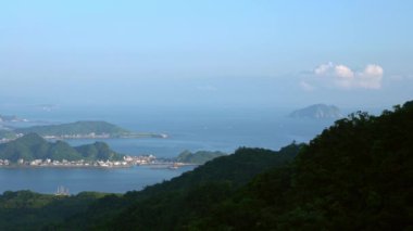 4K, New Taipei 'deki Keelung Shenao Balıkçılık Limanı' nın yükseltilmiş görüntüsü. Sahilde deniz dalgaları olan güzel bir liman manzarası. Dağlı deniz manzarası. Deniz kıyısı, güzel bir yaz günü Dan.