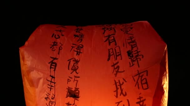 仏事の際にアジアの提灯を灯す人々 台湾の平渓から伝統的な飛行機提灯の間に米紙熱気球が打ち上げられます — ストック動画