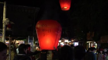 Taipei, Tayvan-12 Şubat 2017: Ağır çekim Budist Festivali sırasında Asya fenerleri fırlatan insanlar, Pingxi-Dan 'den gelen geleneksel uçan fener sırasında pirinç kağıdı sıcak hava balonları fırlatıldı