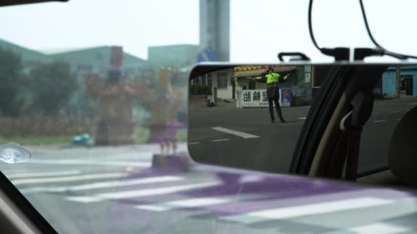 2019年2月5日 通过一个警察的汽车镜像查看移动车辆 身穿制服的亚洲男警察在十字路口用棍子干活 — 图库视频影像
