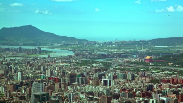 ビルの上から川と山を背景にした台北市中心部のビルの4K空中ビュー101 西エリアの街並み台湾のスカイラインと高角度キャピタルデイタイムダン — ストック動画