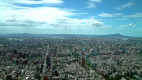 ビルの上から山と雲を背景にした台北市中心部のビルの4K空中風景101 西エリアの街並み台湾のスカイラインを望む高角度キャピタルデイタイムダン — ストック動画