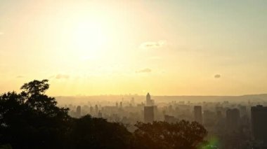 4K, Taipei şehrindeki manzaralı binalar ve dağdan günbatımı. Tayvan 'da şehir manzarası geçmişi. Harika bir gün batımı ve şehir merkezinde turuncu gökyüzü...