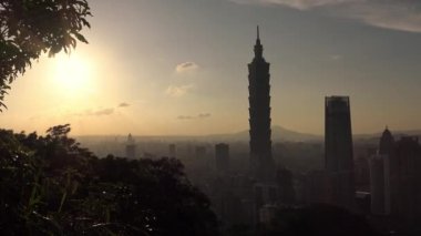 4K Fil Dağı 'ndan gün batımına kadar Taipei 101' in manzara manzarasını yükseltti. Tayvan 'da arka planda şehir manzarası gökdeleni. Harika bir gün batımı ve şehir merkezinde turuncu gökyüzü...