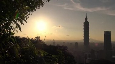 4K Fil Dağı 'ndan gün batımına kadar Taipei 101' in manzara manzarasını yükseltti. Tayvan 'da arka planda şehir manzarası gökdeleni. Harika bir gün batımı ve şehir merkezinde turuncu gökyüzü...