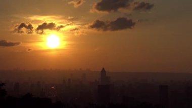 4K, Taipei şehrindeki manzaralı binalar ve dağdan günbatımı. Tayvan 'da şehir manzarası geçmişi. Harika bir gün batımı ve şehir merkezinde turuncu gökyüzü...