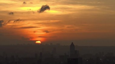 4K, Taipei şehrindeki manzaralı binalar ve dağdan günbatımı. Tayvan 'da şehir manzarası geçmişi. Harika bir gün batımı ve şehir merkezinde turuncu gökyüzü...
