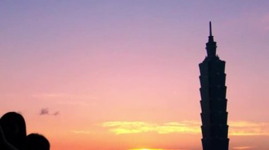 Siluet turisti Asyalı arkadaşlar, Fil Dağı 'nda Taipei Gökdeleni' nin arka planında Taipei 101 'i inşa ederek güzel günbatımında akıllı telefonlarıyla selfie çekiyorlar.