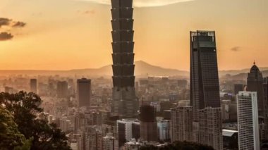 Yüksek manzara manzaralı Taipei 101 'i gün batımına göre inşa ediyor. Tayvan 'da arka planda şehir manzarası gökdeleninin zaman çizelgesi. Harika bir gün batımı ve şehir merkezinde turuncu gökyüzü...