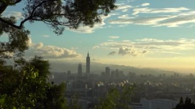 4K Taipei şehrinin gökyüzü manzarası ikonik Taipei 101 binası diğer binaların üzerinde yükseliyor ve Dahu Park-Dan dağından gün batımına doğru yükseliyor.